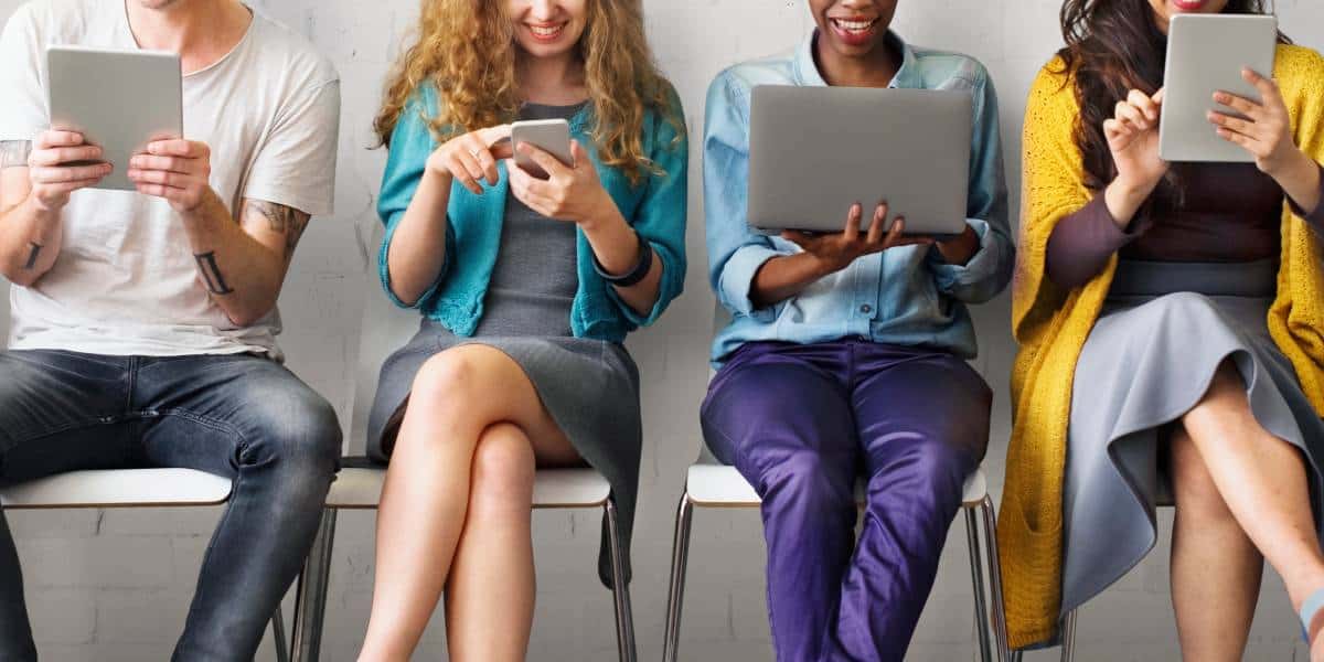 A group of people working with different devices protected by a Buda managed IT team.