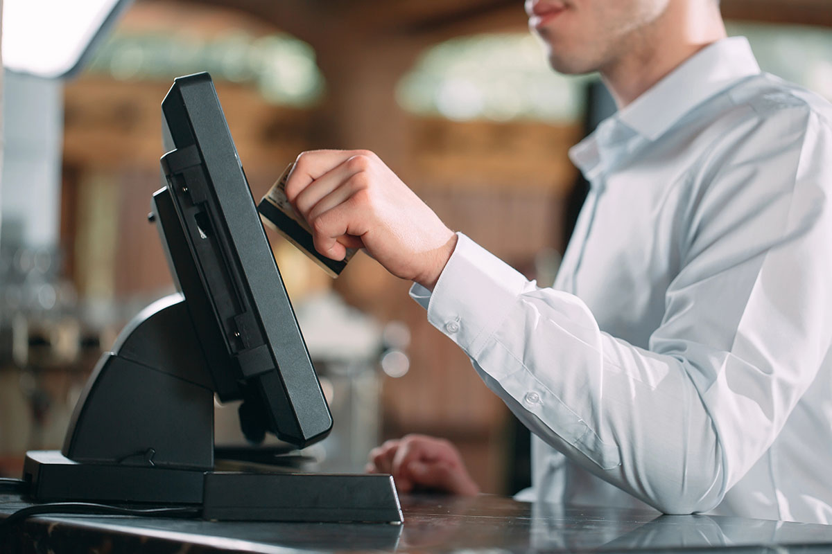 Person uses POS terminal for card transaction.